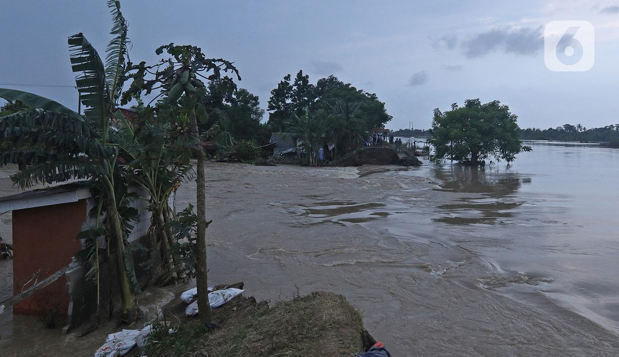 Suasana banjir akibat tanggul jebol di Desa Sumberurip Pebayuran, Kabupaten Bekasi, Jawa Barat, Senin (22/2/2021). Banjir akibat luapan sungai Citarum mengakibatkan 5 Desa terisolir selama tiga hari akibat tanggul sungai Citarum jebol. (Liputan6.com/Herman Zakharia)