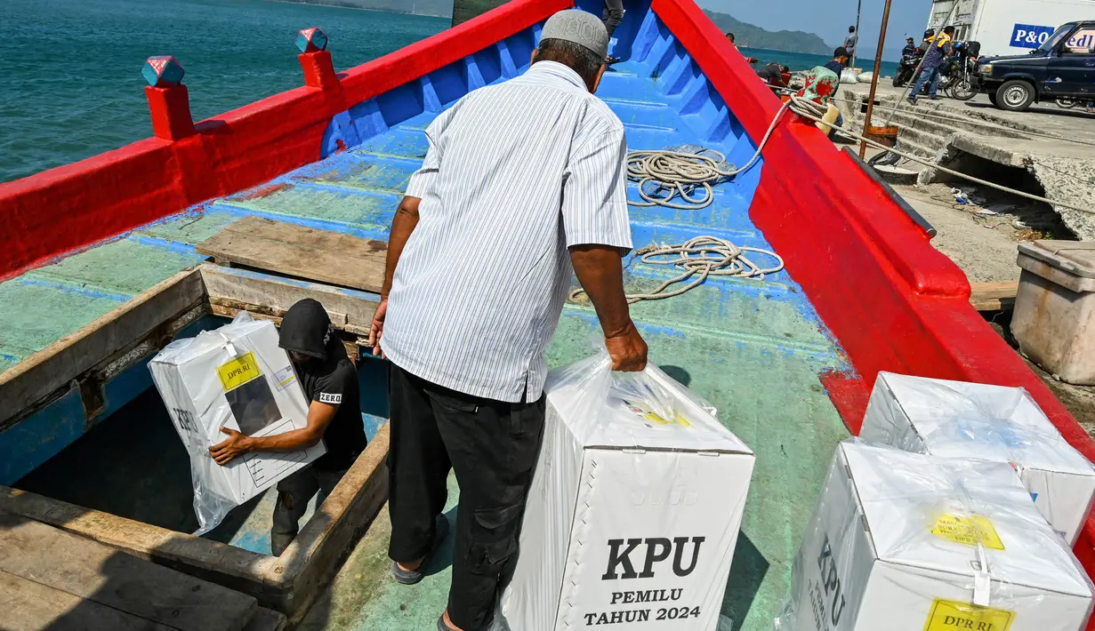 Para pekerja memuat logistik pemilu 2024 ke dalam perahu menuju pulau-pulau terpencil, di Pulo Aceh, Banda Aceh pada 12 Februari 2024. (CHAIDEER MAHYUDDIN/AFP)