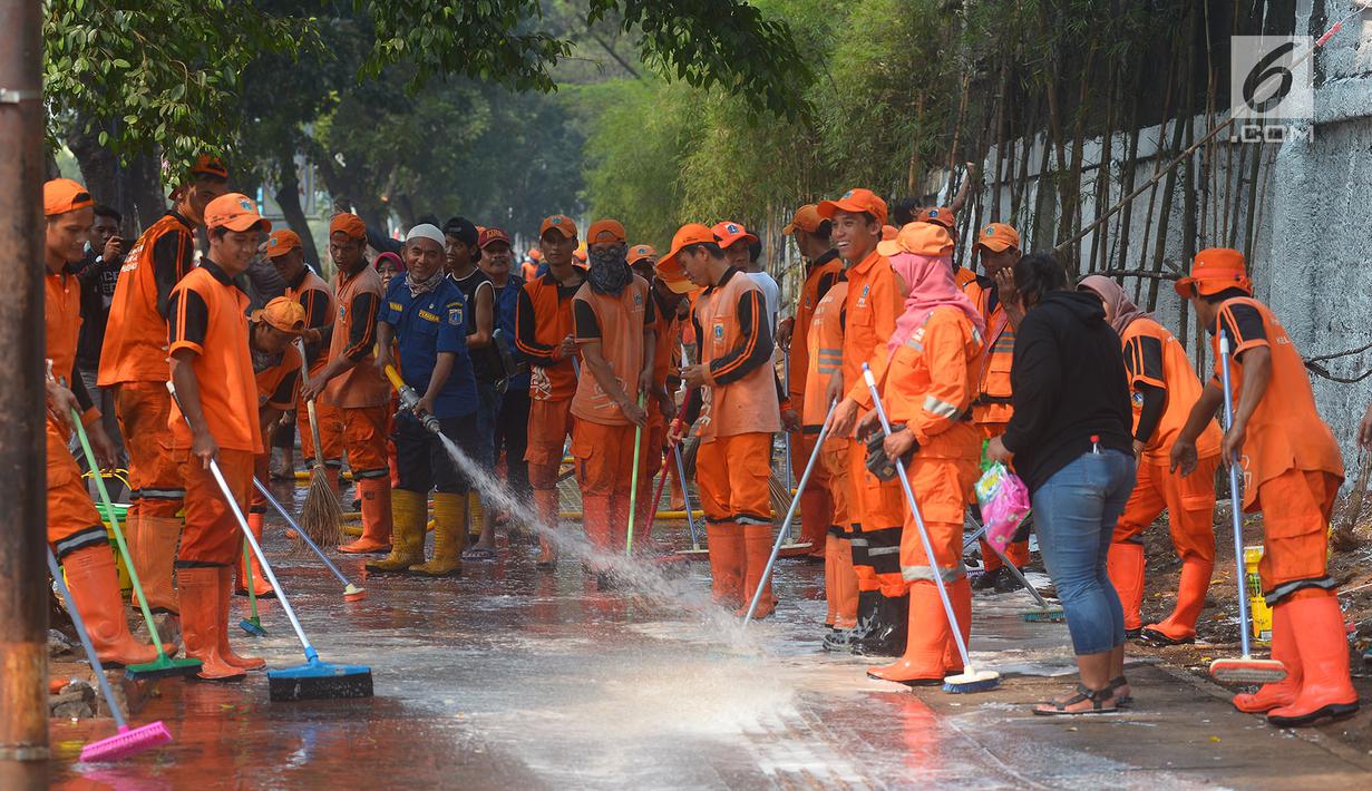 Petugas PPSU membersihkan trotoar di Jalan Asia Afrika, Jakarta, Kamis (2/8). Trotoar yang di pakai para pedagang kaki lima ini di bersihkan guna jelang Asian Games 2018 di Jakarta dan Palembang. (Merdeka.com/Imam Buhori)