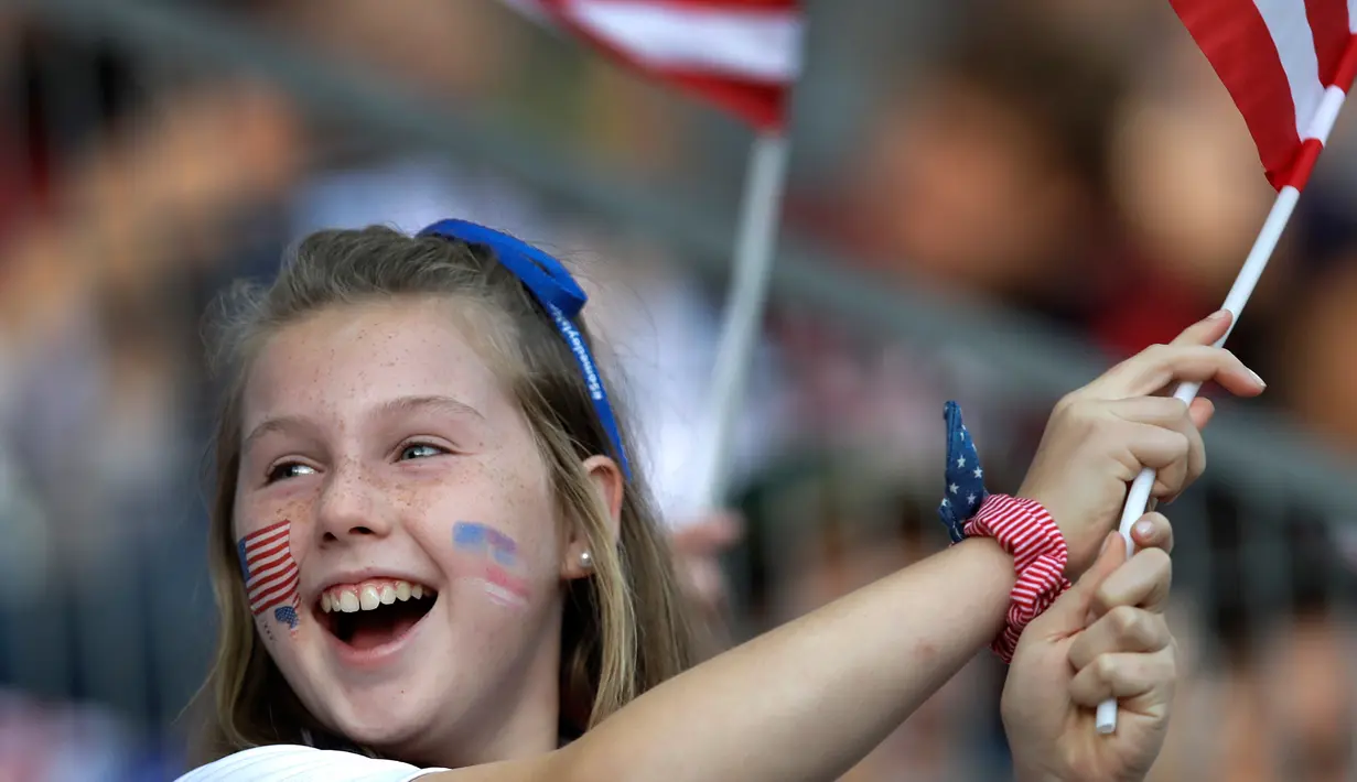 Fans wanita mengibarkan bendera AS sebelum pertandingan Grup F Piala Dunia Wanita 2019 antara Amerika Serikat melawan Thailand di Stadion Auguste-Delaune di Reims, Prancis (11/6/2019). (AP Photo/Alessandra Tarantino)