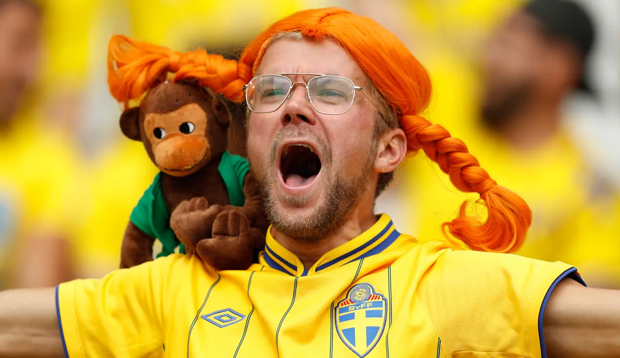 Seorang suporter Swedia memakai wig dan membawa boneka monyet saat mendukung timnya melawan Irlandia di pertandingan Grup E Euro 2016 di Stade de France, Saint-Denis, Paris, (13/6). (REUTERS/John Sibley)