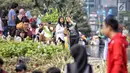 Warga berswafoto saat Car Free Day (CFD) di kawasan Bundaran HI saat Car Free Day (CFD), Jakarta, Minggu (24/6). Mereka juga berfoto di salah satu ikon Jakarta, yakni Patung Selamat Datang. (Liputan6.com/Faizal Fanani)