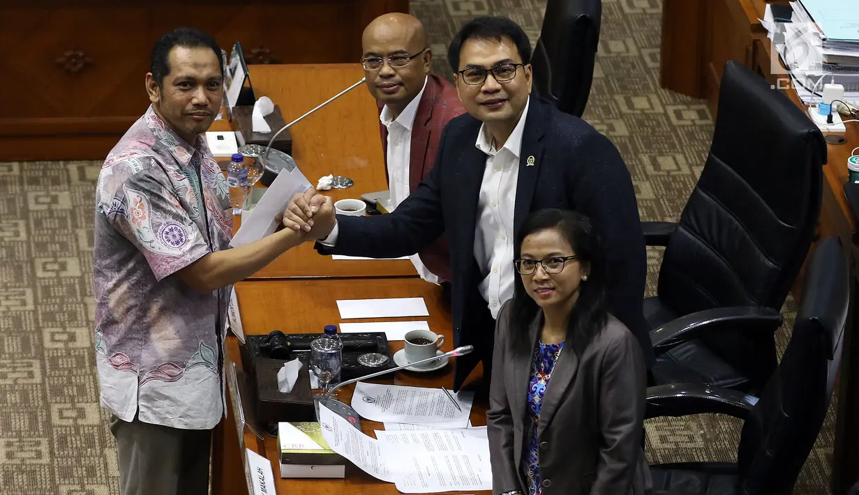 Calon Pimpinan KPK Nurul Ghufron berjabat tangan dengan Ketua Komisi III DPR Aziz Syamsuddin (kanan) usai menerima amplop berisi tema makalah yang harus dibuat, saat uji kelayakan dan kepatutan capim KPK di Kompleks Parlemen, Senayan, Jakarta, Senin (9/9/2019). (Liputan6.com/Johan Tallo)