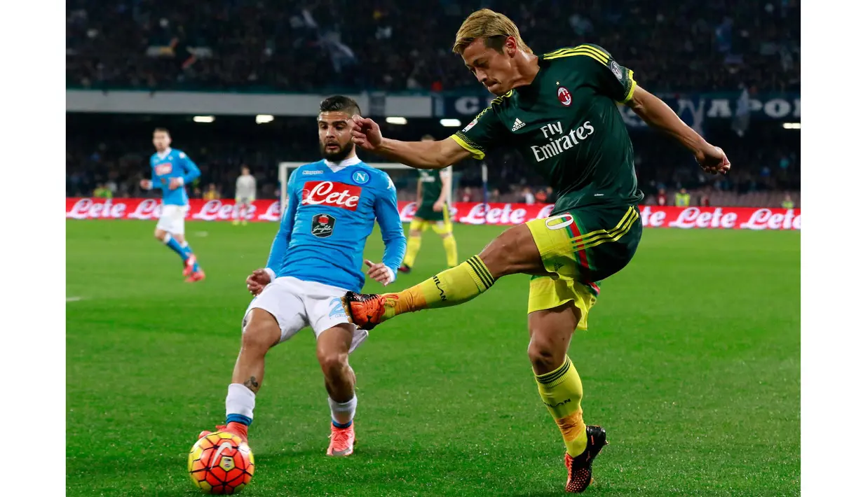 Pemain AC Milan,  Keisuke Honda (kanan) melakukan tembakan saat dihadang pemain SSC Napoli Lorenzo Insigne pada lanjutan Serie A pekan ke-26 di San Paolo; Naples; Selasa (23/2/2016) dini hari WIB. (AFP/Carlo Hermann)