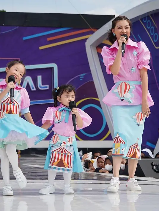 Tampil bersama kedua putrinya, Sarwendah tampil awet muda dengan puffy shirt berwarna pink dan midi skirt berwarna biru. Penampilan Sarwendah makin playful dengan festival print di outfitnya. (instagram/sarwendah29)