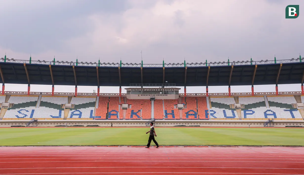 Seorang pekerja terlihat berjalan di Stadion Si Jalak Harupat, Kecamatan Kutawaringin, Kecamatan Bandung, Jawa Barat yang tengah dipersiapkan untuk salah satu venue Piala Dunia U-17 2023 pada Sabtu (21/10/2023). Stadion SJH akan menjadi kandang untuk Grup D, Grup F, dan dua laga babak 16 besar. (Bola.com/Bagaskara Lazuardi)
