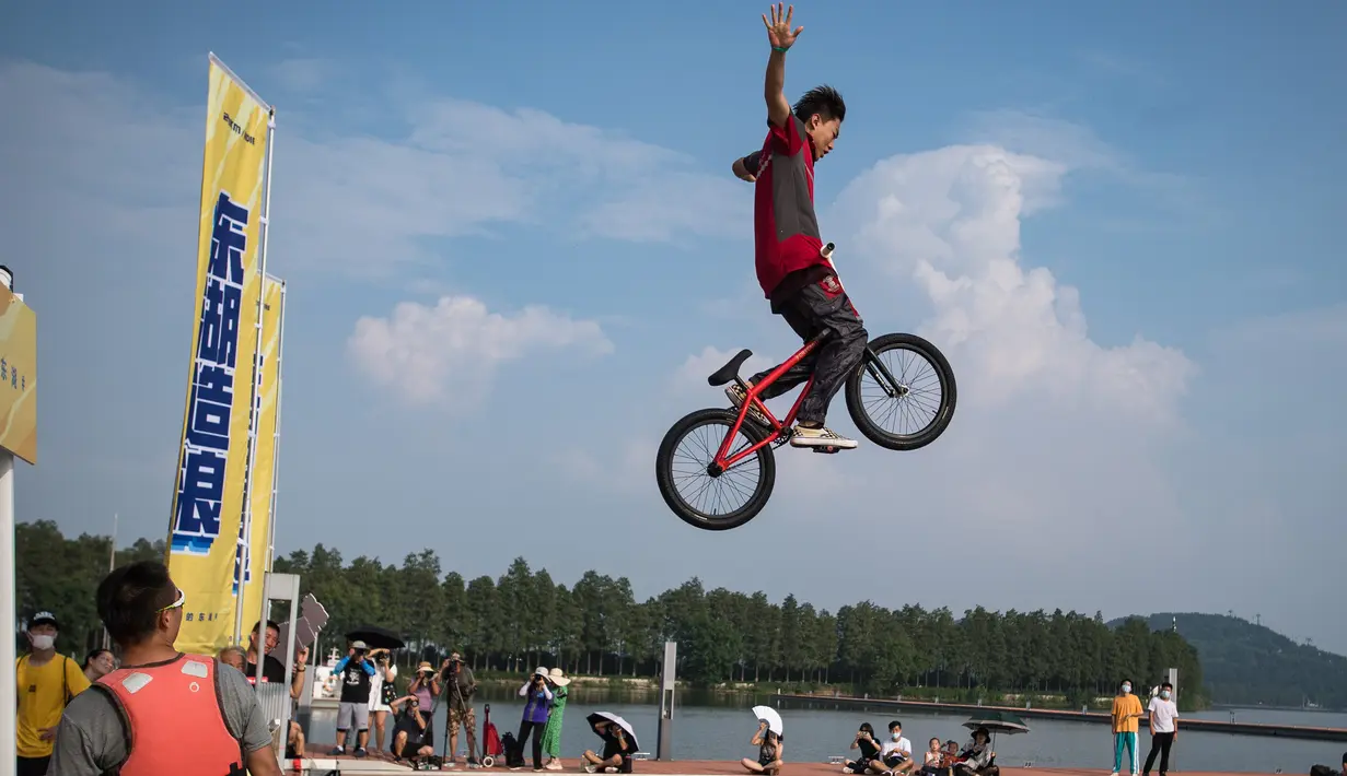 Seorang pesepeda melompat ke Danau Timur menggunakan sepeda BMX dalam ajang tahunan festival lompat air (water jump) BMX di Wuhan, ibu kota Provinsi Hubei, China tengah, pada 22 Agustus 2020. (Xinhua/Xiao Yijiu)
