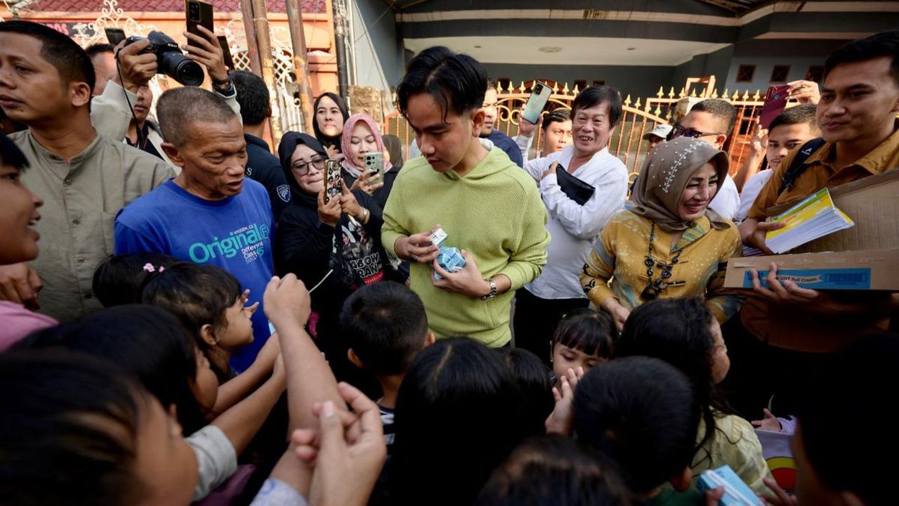 FOTO: Gaya Gibran Blusukan Bareng Raffi Ahmad di Jakarta, Bagikan Susu dan Buku ke Anak-Anak