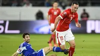 Penyerang Swiss, Josip Drmic (kanan) berusaha melewati adangan pemain San Marino, Marco Berardi, pada Kualifikasi Euro 2016 Grup E, di St Gallen (9/10/2015). Drmic absen pada putaran final Piala Eropa 2016.  (EPA/Gian Ehrenzeller)