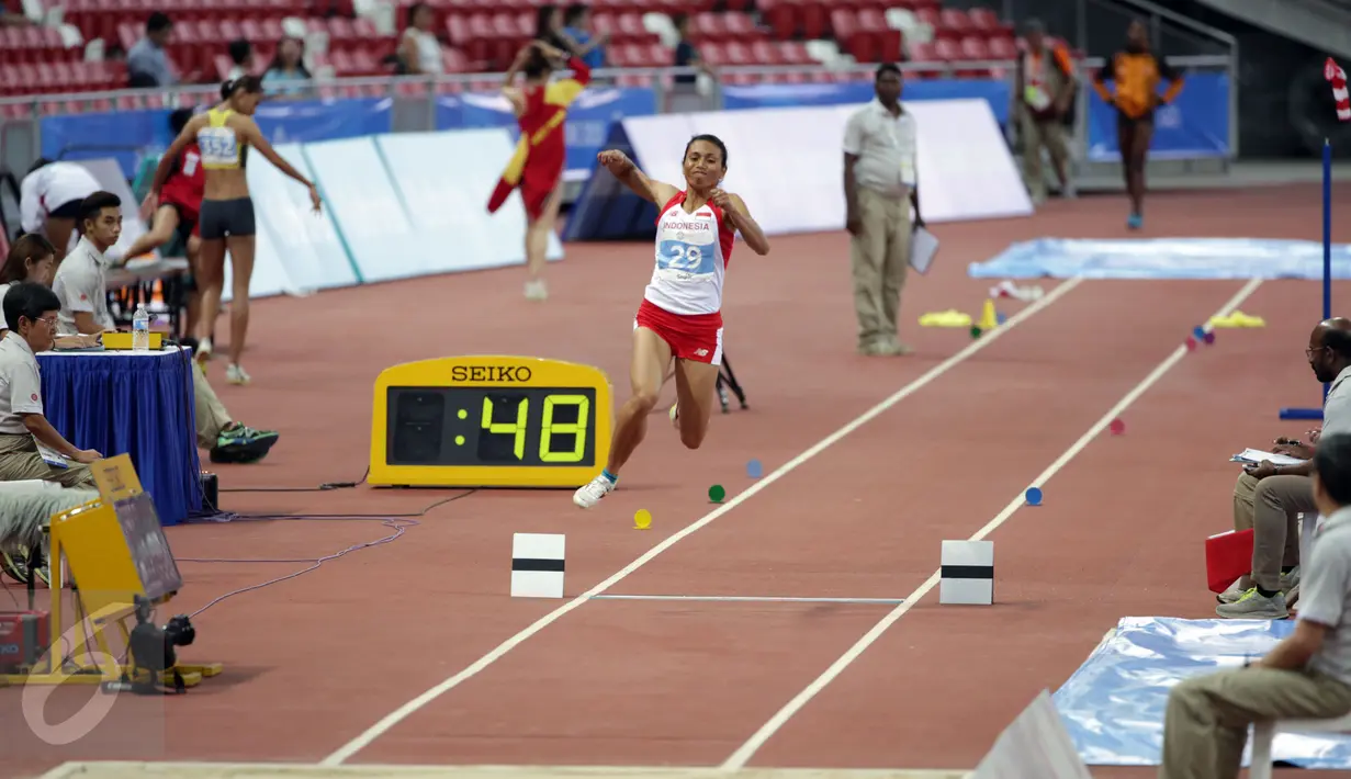 Atlet putri Indonesia, Maria Londa saat melakukan lompatan di nomor lompat jangkit di National Stadium, Singapura, Kamis (11/6/2015). Maria mencatat lompatan sejauh 13,75 meter dan berhasil meraih medali emas. (Liputan6.com/Helmi Fithriansyah)
