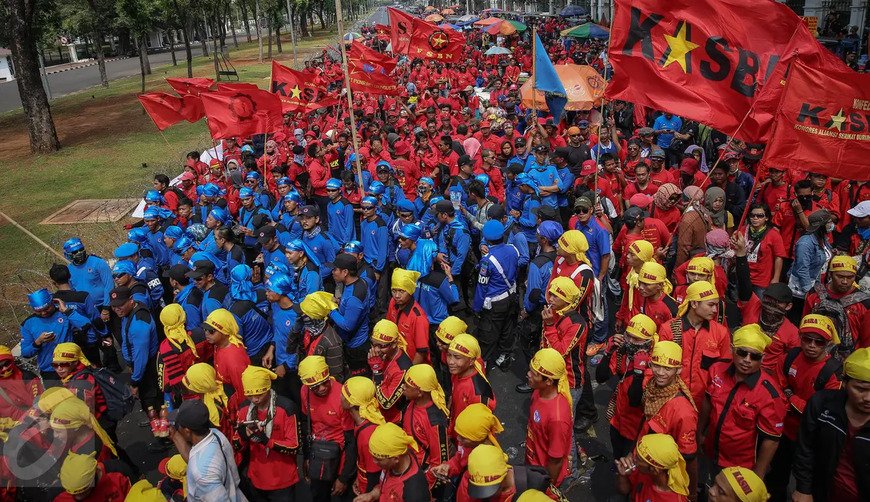 Ribuan buruh dari berbagai serikat, membawa bendera organisasi saat unjuk rasa di depan Istana Negara, Jakarta, Kamis (15/10). Aksi mereka untuk menyatakan penolakan terhadap paket kebijakan ekonomi jilid IV. (Liputan6.com/Faizal Fanani)