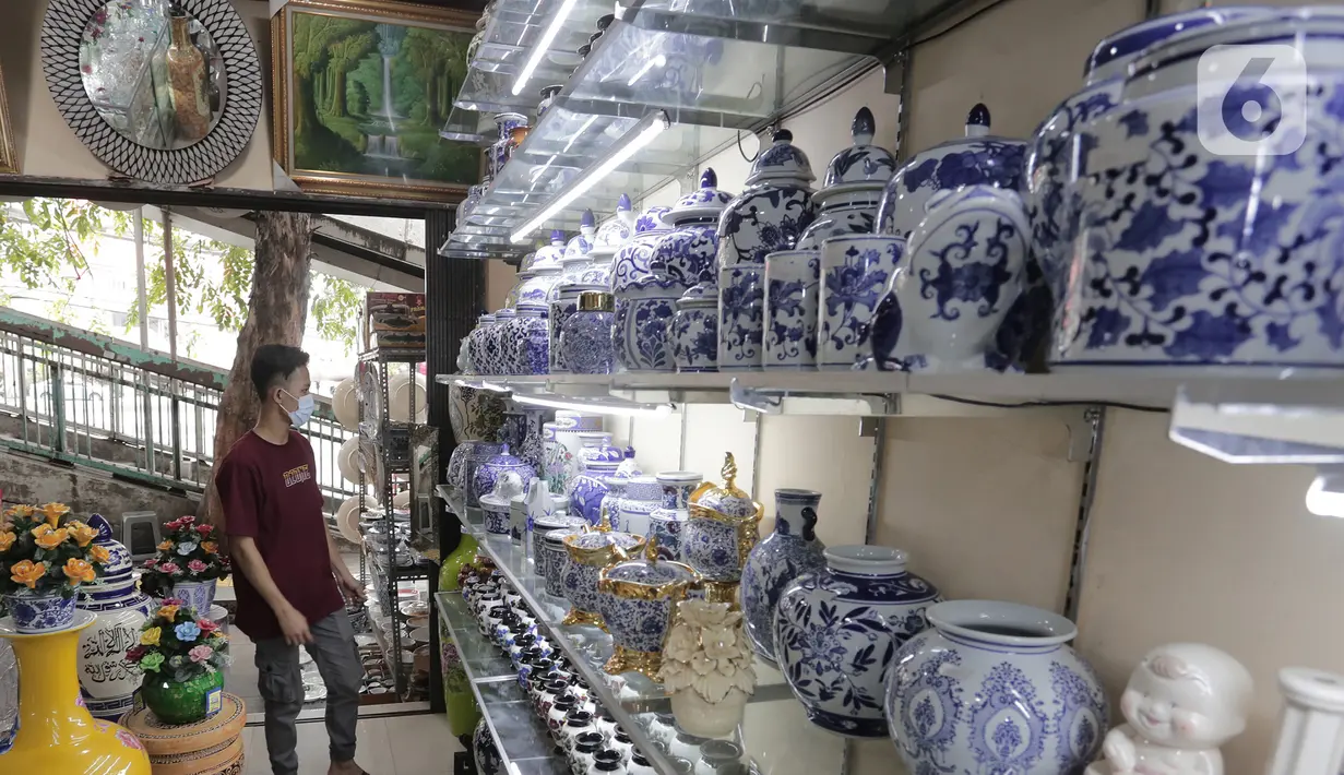 Pembeli melihat produk keramik yang dijual di kios kerajinan keramik kawasan Tanjung Priuk, Jakarta Utara, Kamis (23/9/2021). Pedagang mengaku pasokan keramik menurun hingga 70 persen seiring dangan pembatasan produksi pabrik akibat perpanjangan PPKM. (Liputan6.com/Herman Zakharia)