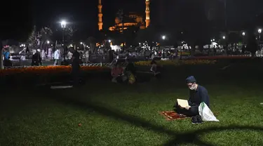 Seorang pemuda membaca dari Al-Quran sehari sebelum salat Jumat pertama di monumen tengara dalam 86 tahun setelah konversi kembali ke masjid di luar dirinya era-Bizantium Hagia Sophia, di distrik bersejarah Sultanahmet Istanbul, Kamis, (23/7/2020). (AP Photo/Omer Kuscu)