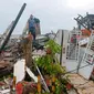 Warga memeriksa rumah-rumah yang rusak akibat gempa di Mamuju, Sulawesi Barat, Indonesia, Jumat (15/1/2021). Gempa yang berpusat di timur laut Majene tersebut terjadi pada Jumat (15/1/2021) pukul 02.28 Wita. (AP Photo/Rudy Akdyaksyah)