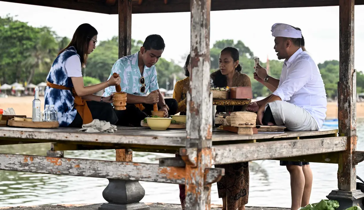 Dalam kunjungannya, Gibran Rakabuming Raka dibacakan kakawin dan meminum jamu kelor oleh Co Founder Samsara Living Museum, Ida Bagus Agung Gunarthawa. (SONNY TUMBELAKA/AFP)