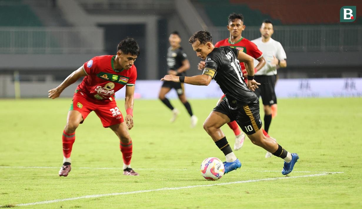 Egy Maulana Vikri (kanan) mencoba melewati Riswan Lauhin dalam pertandingan Dewa United melawan Persebaya Surabaya pada pekan ke-24 BRI Liga 1 di Stadion Pakansari, Kabupaten Bogor, Jumat (21/2/2025) malam WIB. (Bola.com/Abdul Aziz)