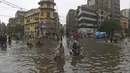 Orang-orang menyeberangi jalan yang banjir setelah hujan deras monsun di Karachi (25/7/2022). Keadaan darurat cuaca diumumkan di Karachi karena hujan muson yang lebih deras dari biasanya terus melanda kota terbesar di Pakistan, membanjiri rumah-rumah dan membuat jalan-jalan tidak dapat dilalui. (AFP/Asif Hassan)