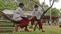 Dua murid SD bermain di atas pohon di sekolah alam Sukawangi, Kabuapaten Bekasi, Jawa Barat, Senin (30/11/2020). Kegiatan bermain di alam terbuka menjadi solusi bagi para murid untuk menghilangkan rasa jenuh usai belajar dimasa pandemi COVID-19. (Liputan6.com/Herman Zakharia)