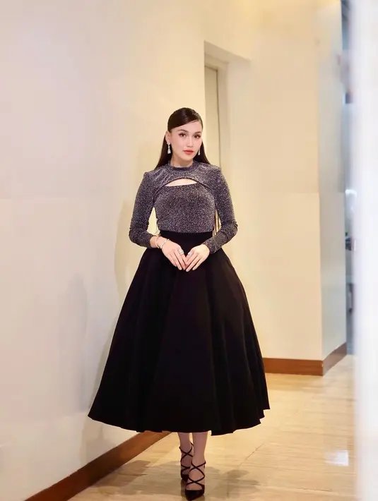 Sekarang mari melihat gaya Ayu Ting Ting saat manggung. Ia tampil menawan dalam balutan atasan penuh kilau bernuansa hitam dengan cut out di bagian dada, dan midi ball skirt hitam, serta high heelsnya yang serasi. [Foto: Instagram/ayutingting92]