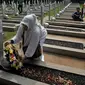 Seorang warga memberikan karangan bunga saat ziarah di TMP Kalibata, Jakarta, Minggu (1/11/2015). Mereka akan membongkar makam keluarga mereka di TMP jika pemerintah melakukan penggusuran terhadap rumah mereka. (Liputan6.com/Johan Tallo)