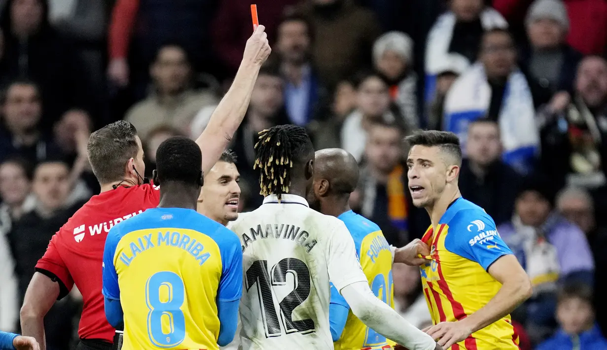 Wasit Javier Alberola Rojas memberikan kartu merah kepada pemain Valencia, Gabriel Paulista saat melawan Real Madrid pada laga Liga Spanyol di Stadion Santiago Bernabeu, (2/2/2023). Kemenangan ini menjaga jarak Madrid dengan Barcelona di papan atas tetap lima angka. Bagi Valencia, mereka harus tetap tertahan di peringkat ke-14 dengan 20 poin. (AFP/Javier Soriano)