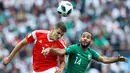 Pemain Rusia Roman Zobnin berebut bola udara dengan pemain Arab Saudi, Abdullah Otayf dari Arab Saudi selama pertandingan grup A Piala Dunia 2018 di stadion Luzhniki di Moskow, Rusia, (14/6). Rusia menang telak 5-0. (AP Photo/Matthias Schrader)