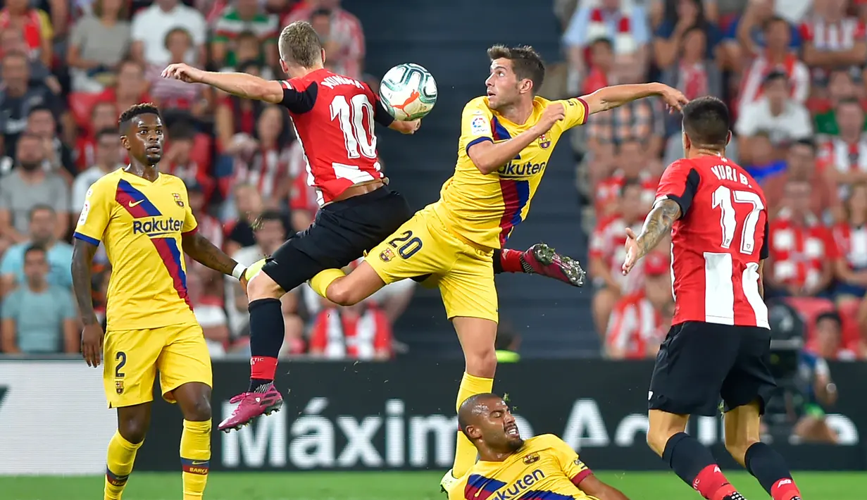 Gelandang Barcelona, Sergi Roberto, berebtu bola dengan penyerang Athletic Bilbao, Iker Muniain, pada laga pekan pertama La Liga 2019-20 di stadion San Mames, Bilbao, Jumat (16/8). Barcelona kalah 0-1 dari Athletic Bilbao. (AFP/Ander Gillenea)