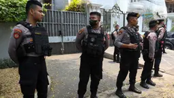 Aparat kepolisian dengan seragam lengkap serta rompi dan senapan berjaga-jaga di depan rumah. (Liputan6.com/Herman Zakharia)