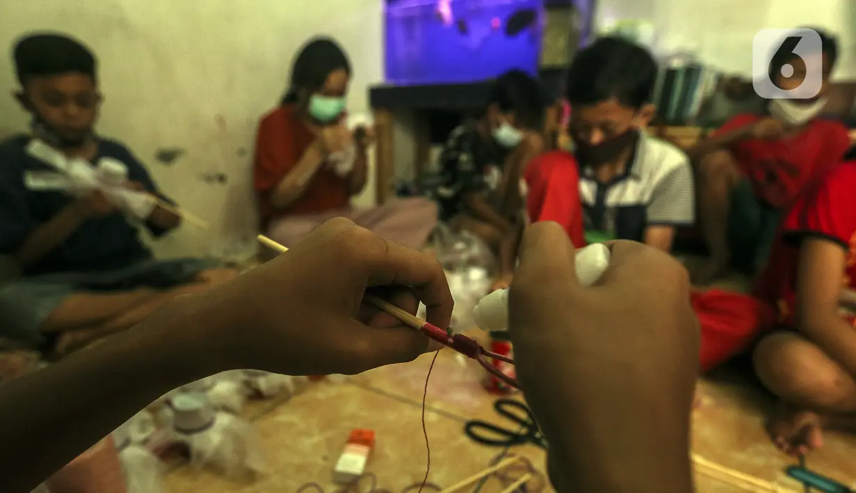 Anak-anak membuat serokan ikan cupang di rumah kontrakan Udin, Sukabumi Selatan, Jakarta Barat, Selasa (22/12/2020). Anak-anak yang ikut bekerja membuat serokan ikan cupang diberi uang jajan. (Liputan6.com/Johan Tallo)
