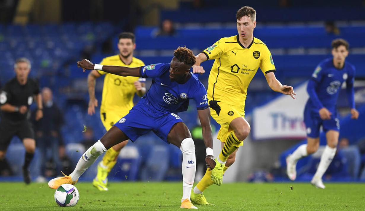 Penyerang  Chelsea, Tammy Abraham, berusaha melewati pemain Barnsley, Cauley Woodrow, pada laga Piala Liga Inggris di Stadion Stamford Bridge, Kamis (24/9/2020). Chelsea menang dengan skor 6-0. (AP Photo/Neil Hall)