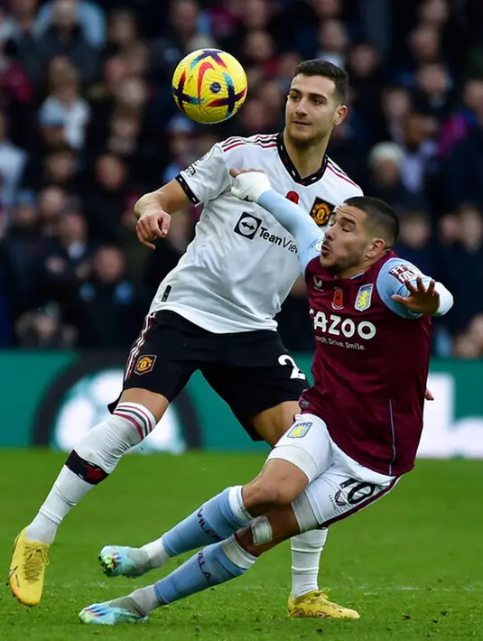 Pemain Manchester United Diogo Dalot (kiri) berebut bola dengan pemain Aston Villa Emiliano Buendia (kanan) pada pertandingan sepak bola Liga Inggris di Villa Park, Birmingham, Inggris, 6 November 2022. Aston Villa mempermalukan Manchester United dengan skor 3-1. (AP Photo/Rui Vieira)