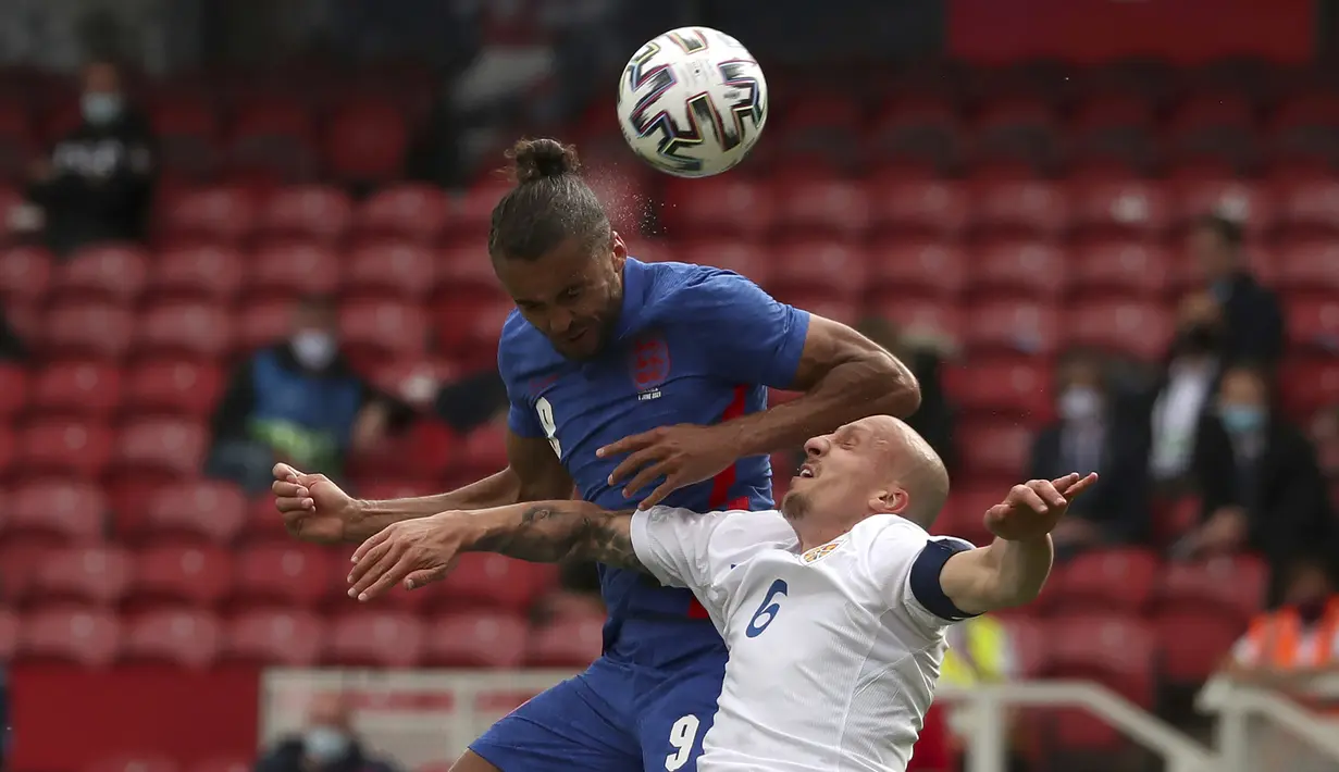Striker Inggris, Dominic Calvert-Lewin (kiri) berduel udara dengan bek Rumania, Vlad Chiriches dalam laga uji coba menjelang berlangsungnya Euro 2020 di Riverside Stadium, Middlesbrough, Minggu (6/6/2021). Inggris menang 1-0 atas Rumania. (AP/Scott Heppell/Pool)