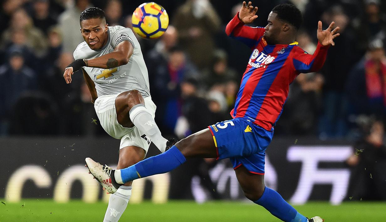 Aksi pemain Manchester United, Antonio Valencia (kiri)  melepaskan tembakan meleawati adangan pemain  Crystal Palace, Jeffrey Schlupp pada lanjutan Premier League di Selhurst Park, London, (5/3/2018). Manchester United menang 3-2.(AFP/ Glyn Kirk)