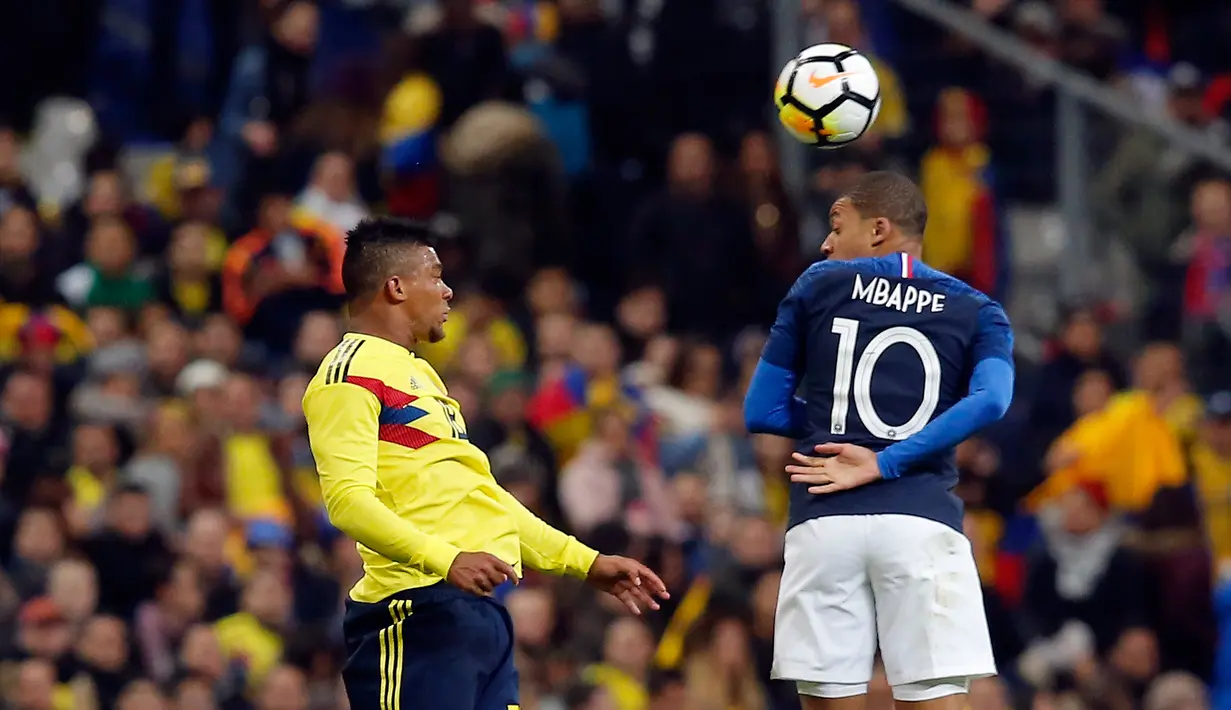 Pemain Prancis, Kylian Mbappe (kanan) berebut bola dengan Carlos Bacca dalam pertandingan persahabatan antara Prancis dan Kolombia di Saint-Denis, luar Paris, Prancis,  Jumat (23/3). Kolombia menang 2-3. (AP Photo/Michel Euler)