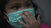 Seorang anak mengenakan masker untuk meminimalisir dampak kabut asap. (Dokumentasi BPNB)