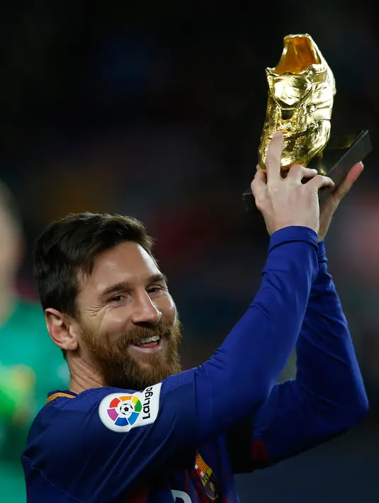 Ekspresi Lionel Messi saat menunjukkan Sepatu Emasnya jelang pertandingan liga Spanyol di stadion Camp Nou di Barcelona (17/12). Messi meraih Sepatu Emas Eropa usai mencetak 37 gol di La Liga musim lalu. (AP Photo/Manu Fernandez)