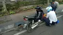 Seorang petugas menggembok roda motor karena parkir liar. (Source: IST)