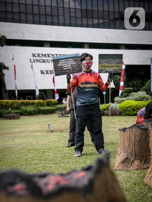 Sejumlah orang yang tergabung dalam Greenpeace menggelar aksi di Kementerian LHK, Jakarta, Kamis (8/4/2021). Mereka menentang rencanan perusakan Hutan Papua yang masih ada di dalam areal perkebunan yang belum dirusak bisa dikembalikan kepada masyarakat adat Papua. (Liputan6.com/Faizal Fanani)