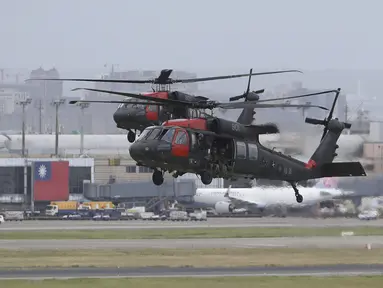 Dua helikopter Sikorsky UH-60 "Black Hawk" mendekat selama latihan militer tahunan Han Kuang yang mensimulasikan serangan terhadap lapangan terbang di Bandara Internasional Taoyuan, Taoyuan, Taiwan, Rabu (26/7/2023). Militer Taiwan dimobilisasi untuk latihan pertahanan rutin dari 24-28 Juli. (AP Photo/ Chiang Ying-ying)