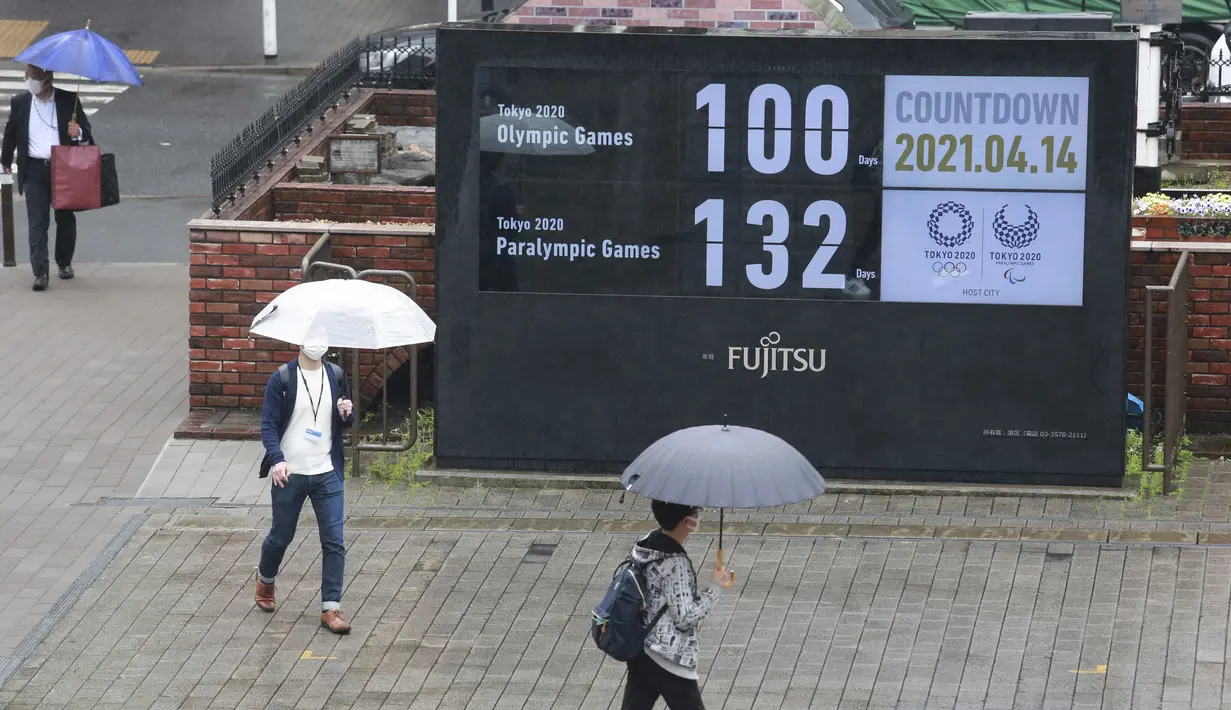 Orang-Orang berjalan di dekat jam hitung mundur untuk Olimpiade dan Paralimpiade Tokyo untuk menandai 100 hari sebelum dimulainya olimpiade musim panas di Tokyo, Rabu (14/4/2021). Olimpiade Tokyo akan dibuka pada 23 Juli 2021. (AP Photo/Koji Sasahara)