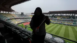 Seorang pekerja tengah membersihkan tempat duduk di tribun penonton Stadion Gelora Bung Tomo (GBT) Surabaya, Jawa Timur, Kamis (9/11/2023) menjelang pembukaan Piala Dunia U-17 2023 yang akan diselenggarakan pada Jumat, 10 November 2023. (Bola.com/Bagaskara Lazuardi)