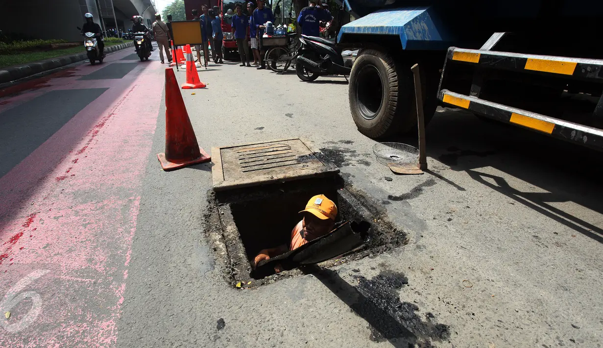 Petugas PPSU menemukan kulit kabel di gorong-gorong saluran air Jalan Gatot Subroto, Jakarta Selatan, Senin (6/3). Kulit kabel ini dianggap menjadi penyebab utama terjadinya banjir di Jalan Gatot Subroto pada 2 Maret 2017 lalu. (Liputan6.com/Johan Tallo)
