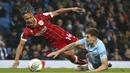 Striker Bristol City, Bobby Reid, terjatuh saat berebut bola dengan bek Manchester City, John Stones, pada leg pertama semifinal Piala Liga Inggris di Stadion Etihad, Selasa (9/1/2018). Manchester City menang 2-1 atas Bristol City. (AP/Dave Thompson)