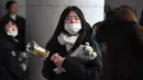 Seorang fans datang membawa bunga untuk memberikan penghormatan kepada Jonghyun SHINee di rumah duka Seoul Asan Hospital, Selasa (19/12). Kepergian Jonghyun SHINee ini menjadi pukulan mendalam bagi keluarga, sahabat, dan penggemar. (JUNG Yeon-Je / AFP)