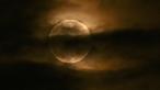Bulan terlihat melalui awan saat gerhana bulan sebagian di Srinagar, India, Jumat (5/5/2023). Gerhana Bulan Penumbra akan muncul pada Jumat (5/5/) hingga Sabtu (6/5) dinihari. (TAUSEEF MUSTAFA / AFP)