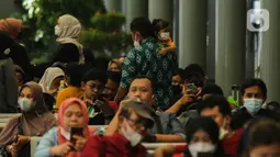 Calon penumpang menggendong anaknya saat menunggu di Stasiun Senen, Jakarta, Sabtu (23/10/2021). PT Kereta Api Indonesia (Persero) kembali memperbolehkan anak-anak usia di bawah 12 tahun naik KA Jarak jauh mulai 22 Oktober 2021. (Liputan6.com/Faizal Fanani)