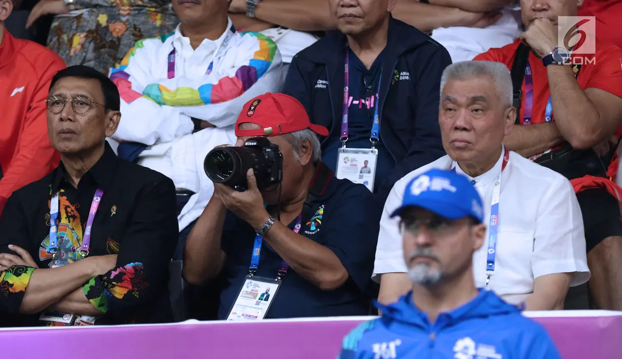 Menteri PUPR, Basuki Hadimuljono(tengah) mengabadikan momen saat laga semifinal bulu tangkis beregu putra Asian Games 2018, Indonesia melawan Jepang di Jakarta, Selasa (21/8). Indonesia unggul dan lolos ke final. (Liputan6.com/Helmi Fithriansyah)