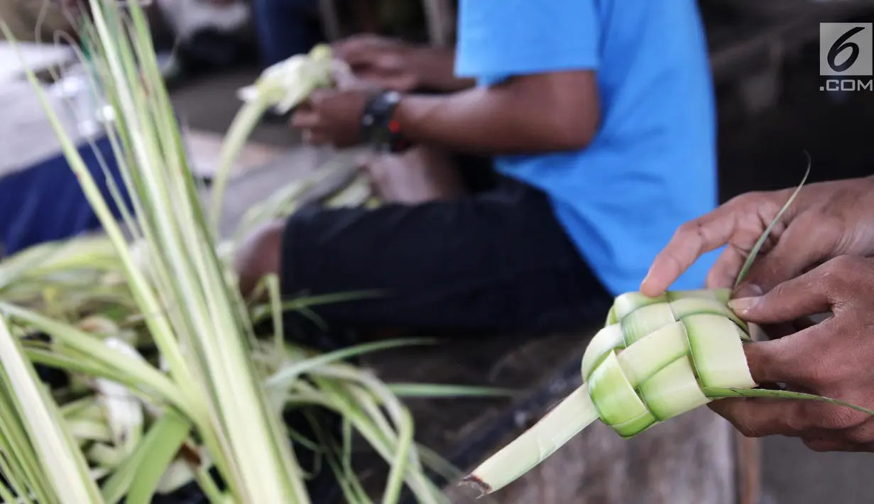 Pedagang membuat kulit ketupat siap jual di Pasar Kemiri Muka, Depok, Jawa Barat, Selasa (12/6). Menjelang Lebaran, pedagang kulit ketupat mengaku kebanjiran pembeli. (Liputan6.com/Herman Zakharia)