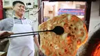 Tukang roti memanggang roti Iran atau taftoon di sebuah toko di Kuwait City, Kuwait, 27 Juni 2019. Taftoon telah menjadi makanan pokok di Kuwait selama beberapa dekade. (YASSER AL-ZAYYAT/AFP)