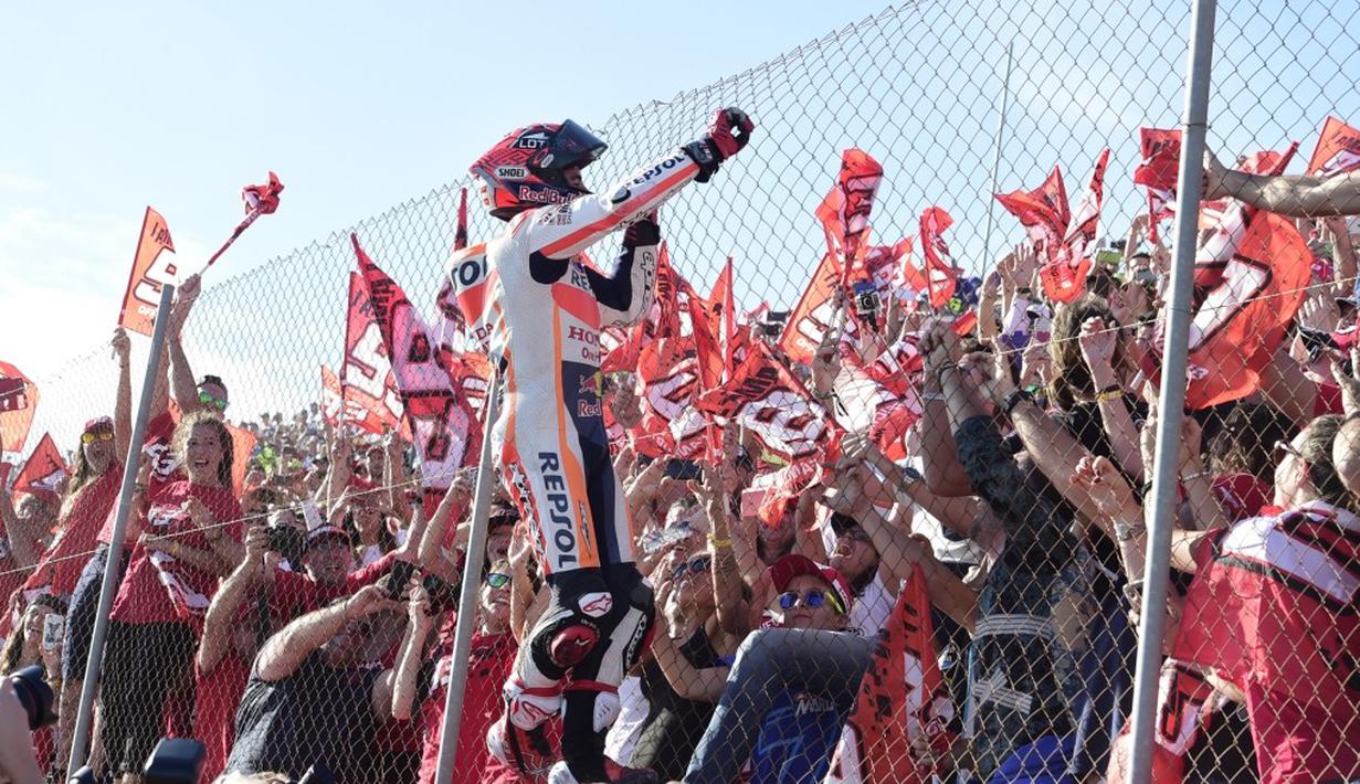 Juara dunia MotoGP 2016, Marc Marquez, merayakan kemenangan di depan pendukungnya setelah berhasil finis kedua dalam balapan MotoGP Valencia di Sirkuit Ricardo Tormo, Minggu (13/11/2016). (AFP/Jose Jordan)